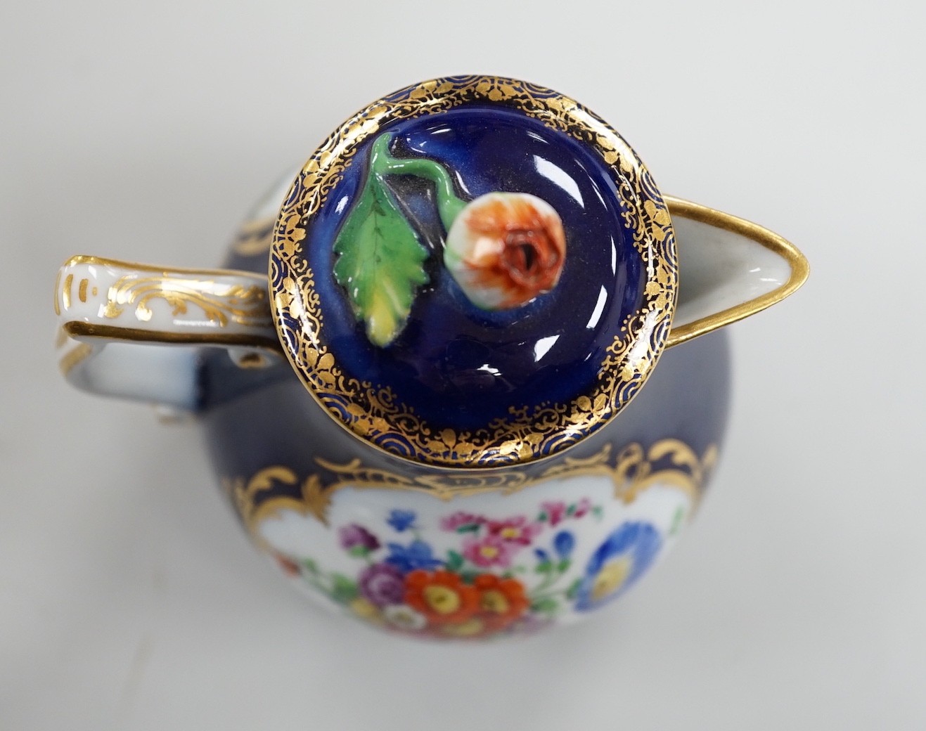 A small 19th century Meissen cobalt blue ground jug and cover, 9.5cm tall